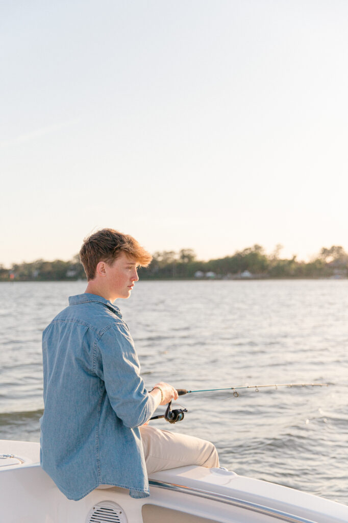 A young bluffton high school senior fishing on the May River for his senior portrait session with Bluffton SC photographer