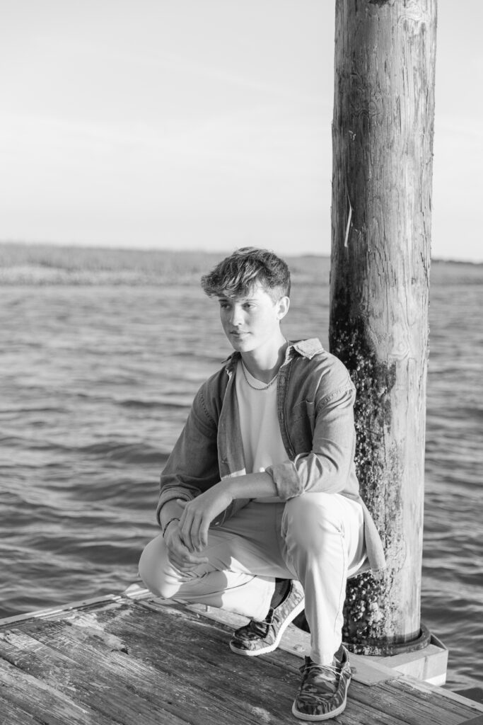 A young man posing on the dock on the May River during his Bluffton Senior Portrait session