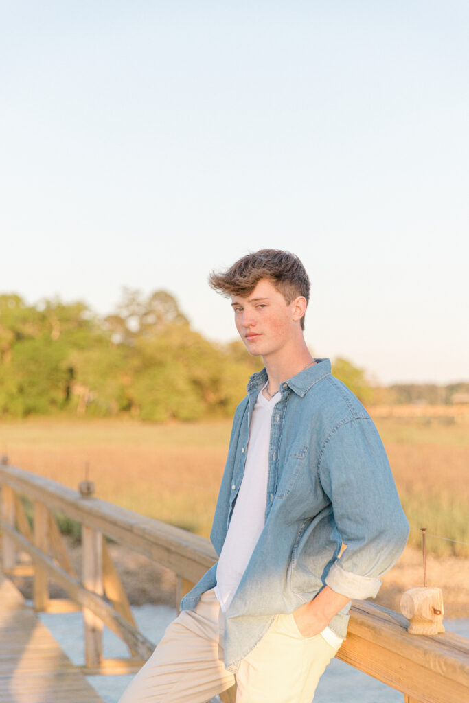 A young high school senior posing on a dock on the May River in Bluffton, SC for his Senior Portrait Session with Bluffton Senior Photographer