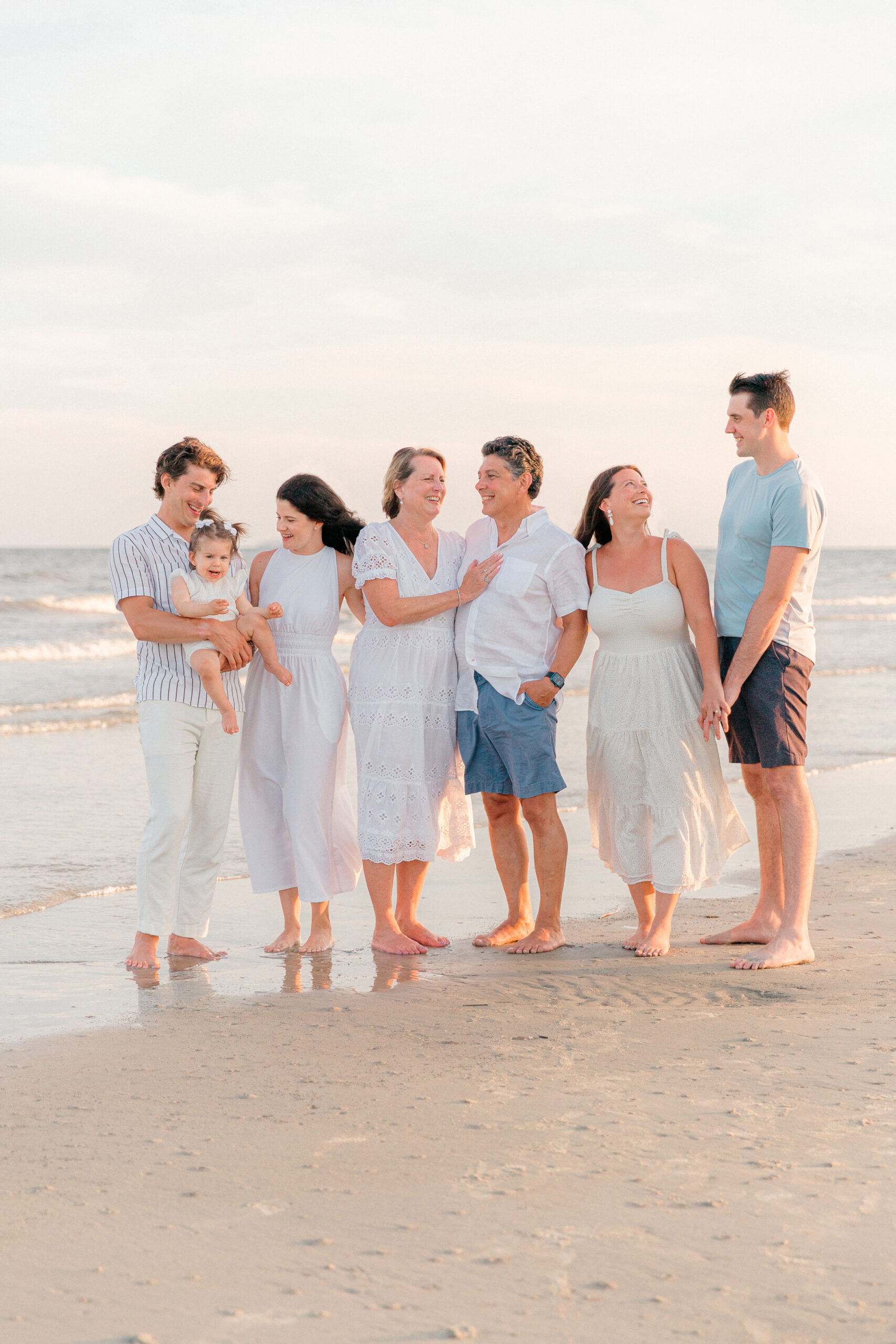 A family smiling and laughing with one another on the beaches of Hilton Head Island, SC, with Lamp and Light Photography.